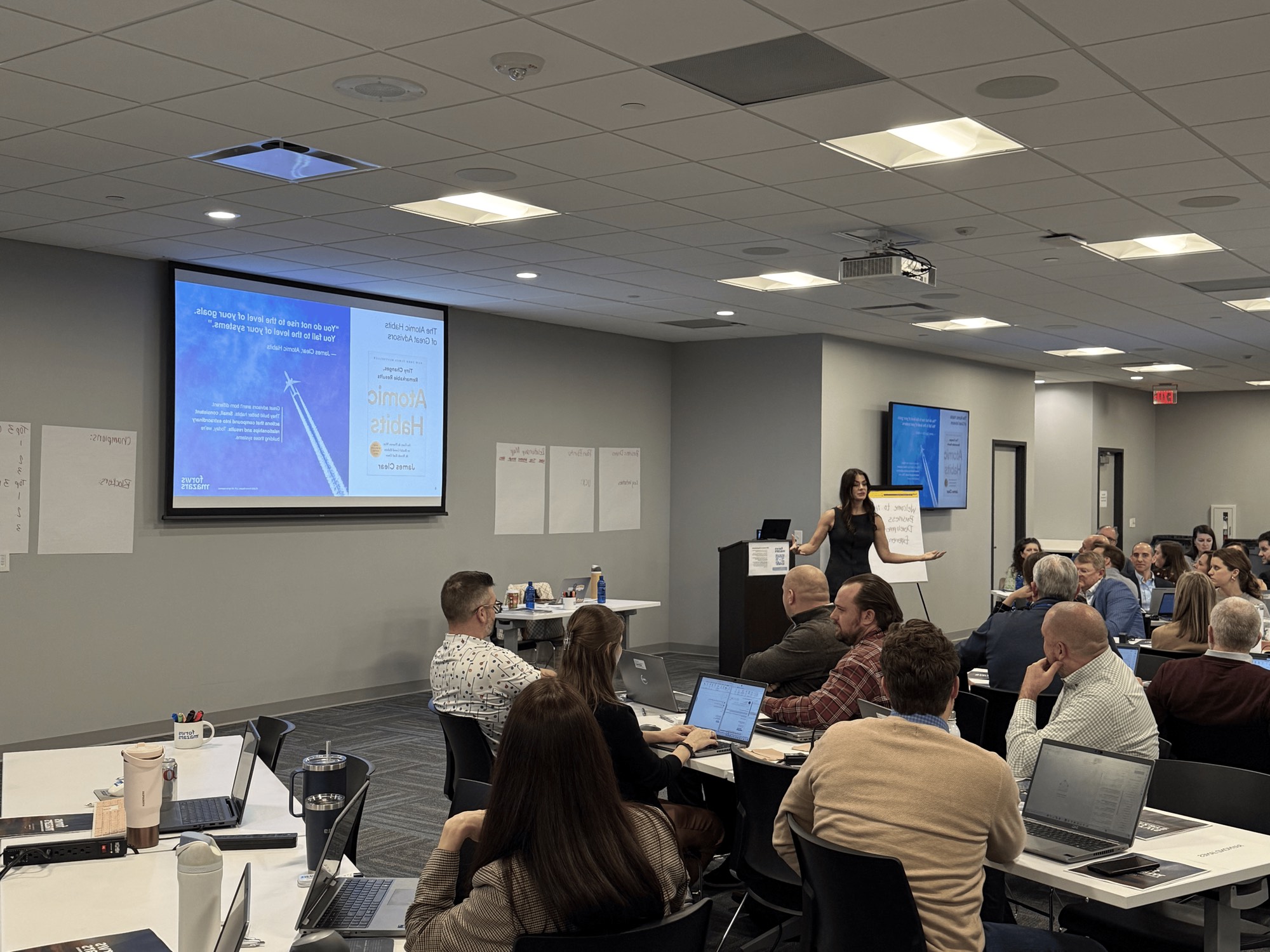 A Clustr instructor leading an AI enablement session for a room of advisors