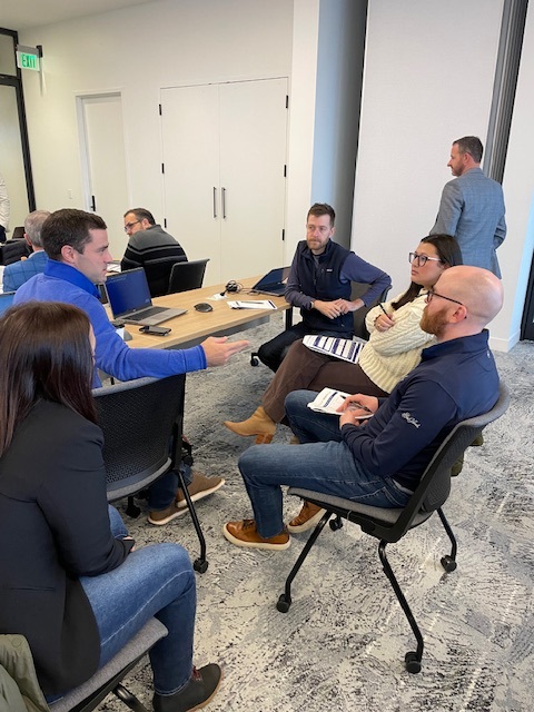 A Clustr trainer coaching a small breakout group during an AI adoption engagement