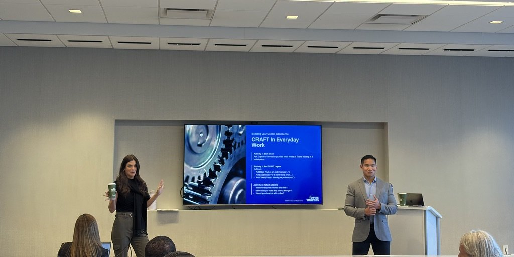 Two Clustr facilitators teaching a Copilot prompting class in a client boardroom