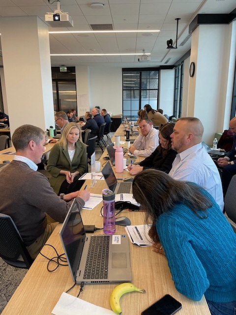 Employees working hands-on with laptops during a Clustr AI upskilling session